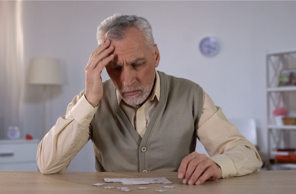 A senior citizen man having memory issues while working on a puzzle