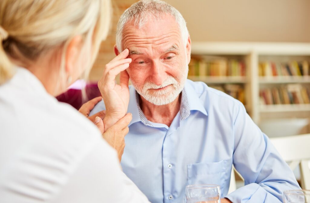 A senior citizen male with alzheimer's talking to a female nurse