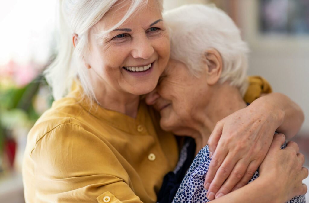 a woman hugs her mother who has dementia